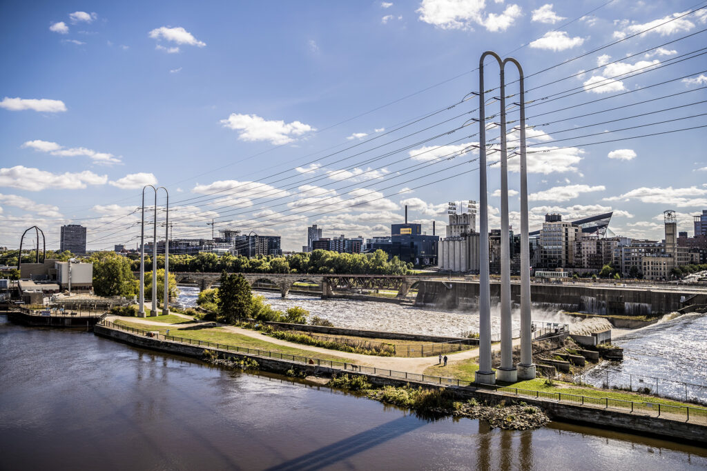 Slender utility structures carrying power lines across a river beside a city