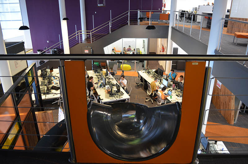 ArcTouch’s Florianópolis office, photographed from beside an indoor slide overlooking the desks