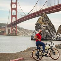 Arda Onal riding an Ariel Rider electric bicycle near the Golden Gate Bridge
