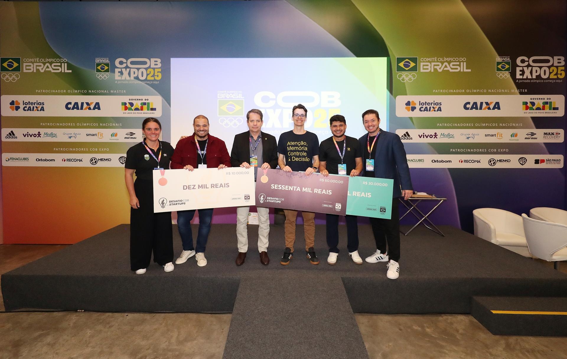 Winners and organizers holding the three prize checks at the 2025 COB startup challenge