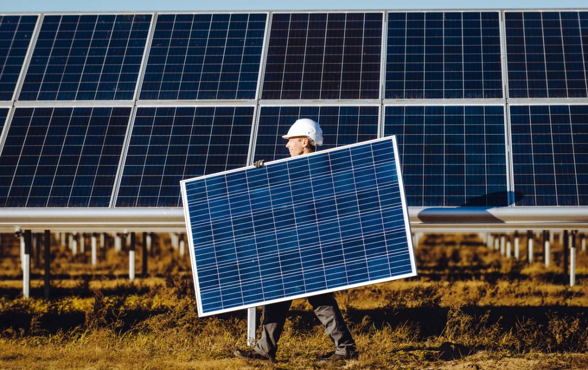 A specialist inspecting a solar panel array