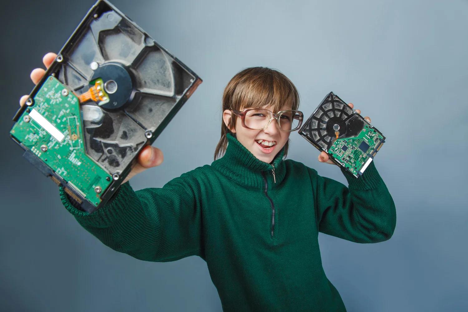 Illustrative photograph of a child holding two exposed hard drives