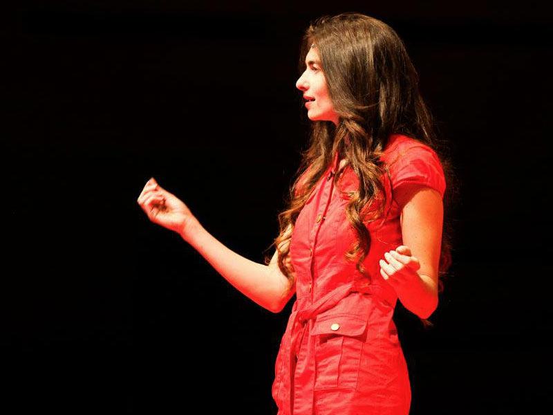 Ariel Garten in a red dress speaking onstage at TEDxToronto in 2011