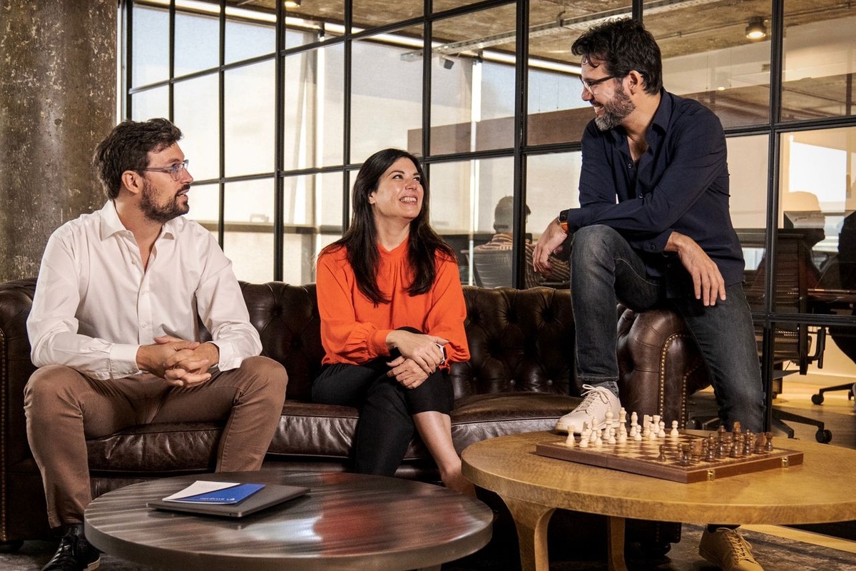 InvGate co-founders Ariel Gesto, Liliana Gary, and Gonzalo Sainz-Trápaga talking together in an office