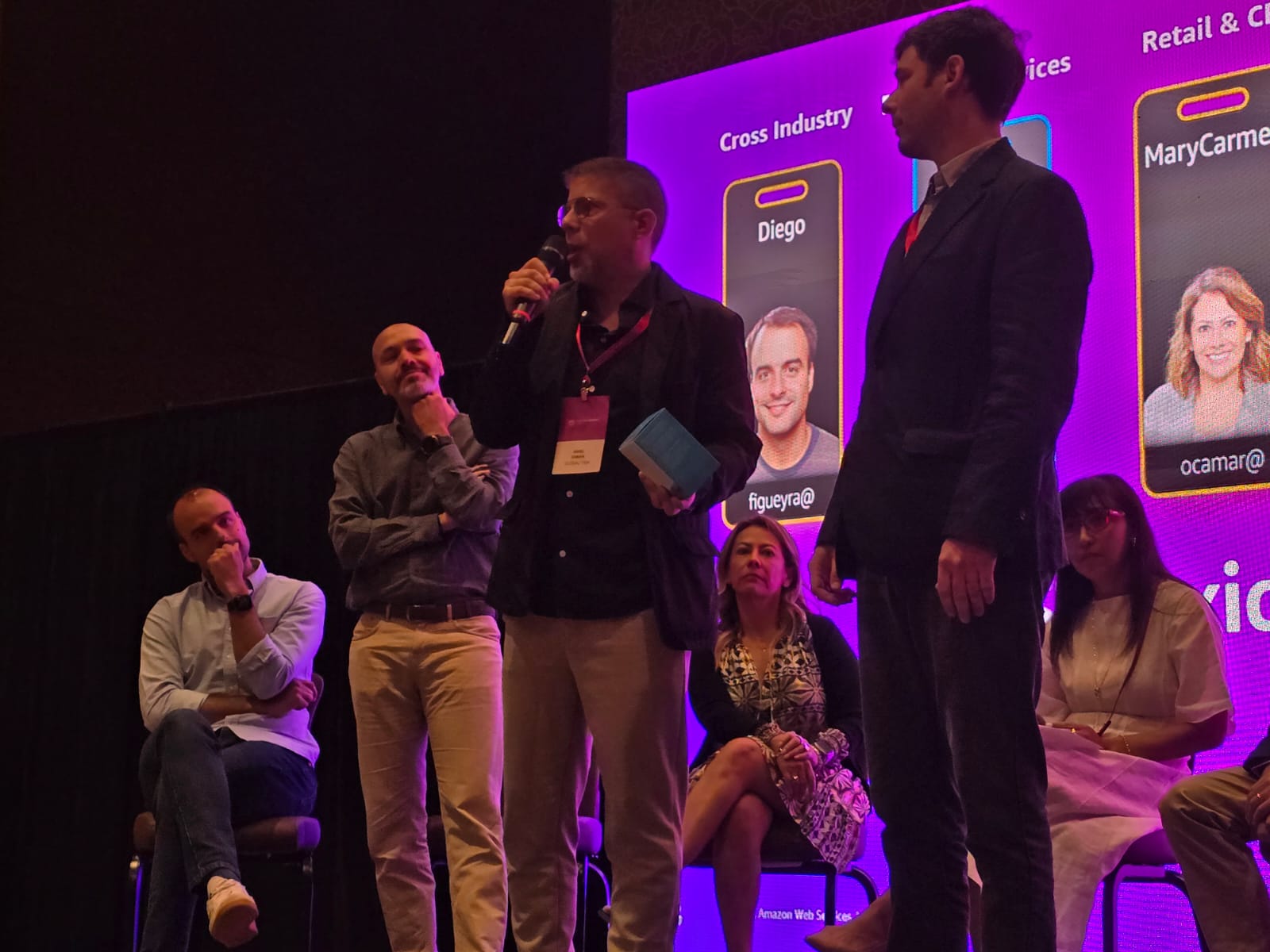 Participants on a purple-lit stage in GlobalTask’s photograph accompanying its AWS Partner Summit recognition announcement