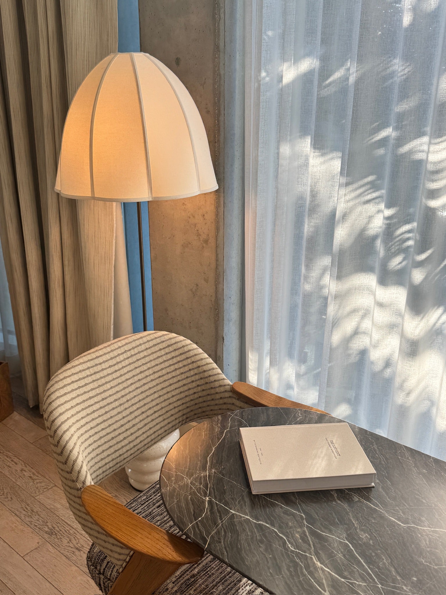 The Life Edit planner on a dark marble table beside a striped chair and a floor lamp