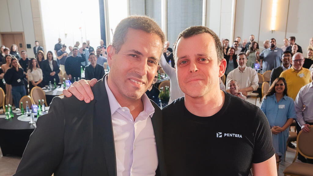 Amitai Ratzon, left, and Arik Liberzon, right, standing together with Pentera colleagues behind them