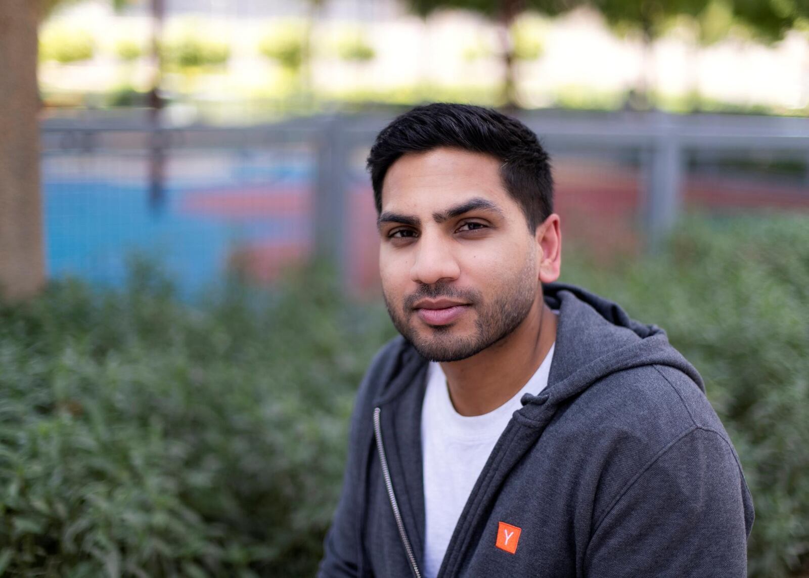 Arjun Mohan seated outdoors in a grey hoodie