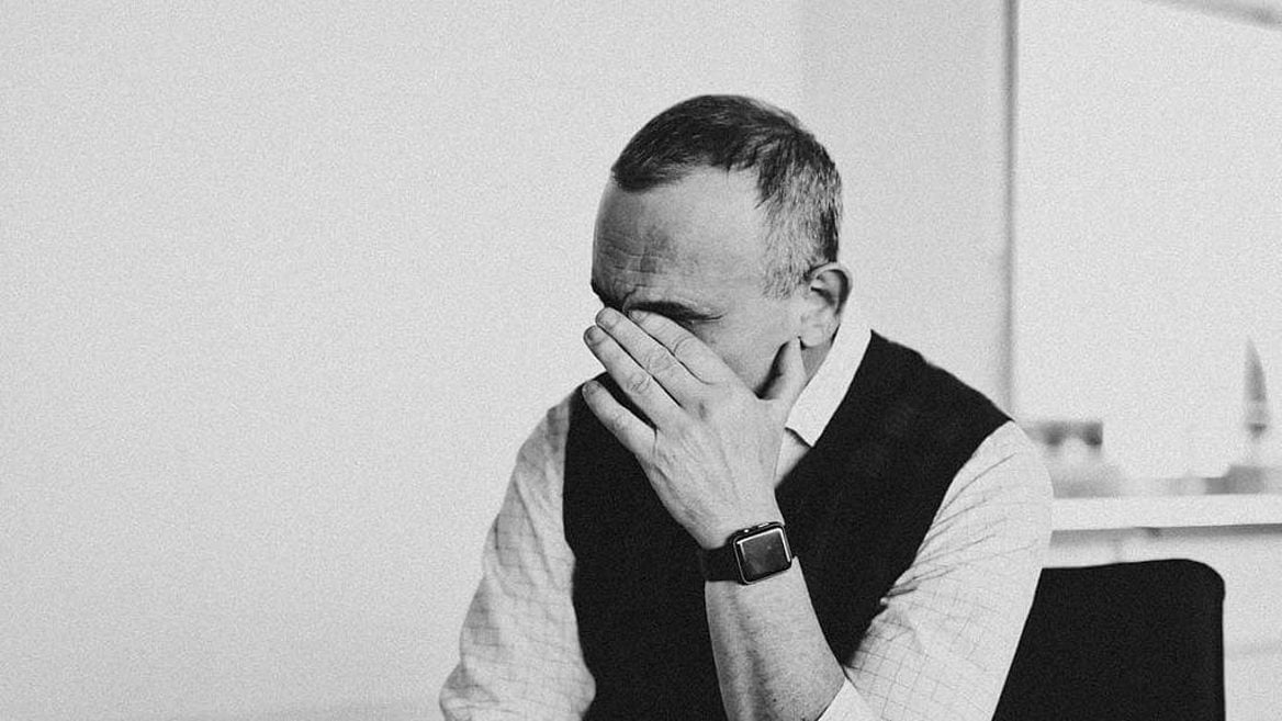Arkadiy Dobkin seated during an interview, his hand raised across his face