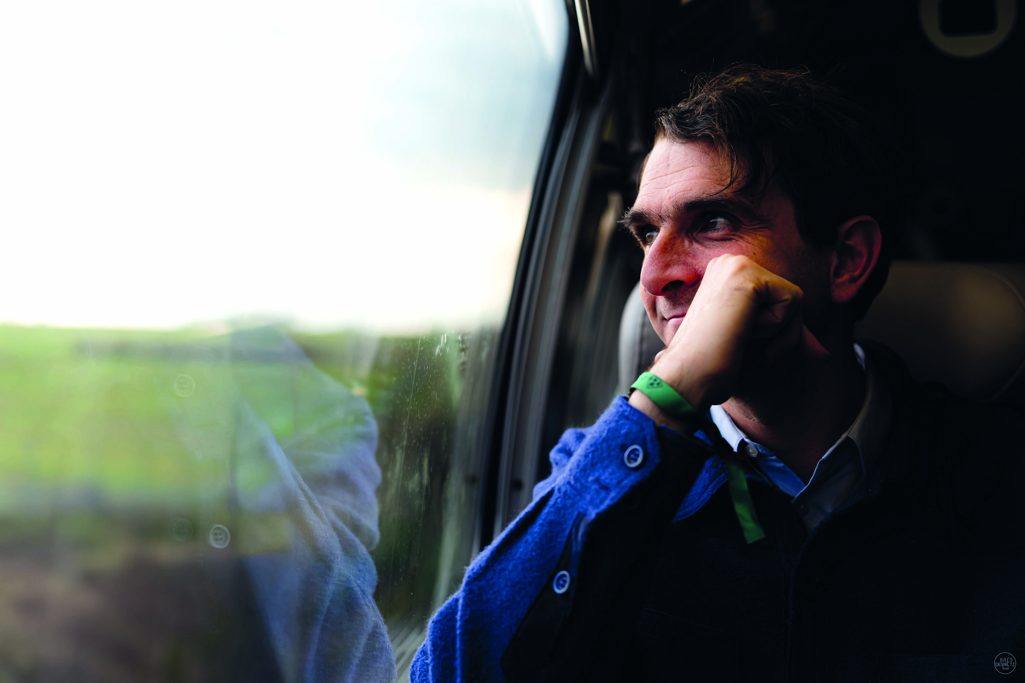 Armand Thiberge sitting beside a window, looking outside
