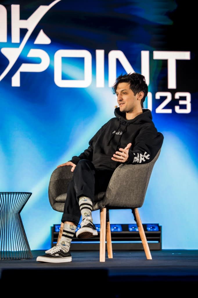 Armani Ferrante seated onstage at Breakpoint 2023, wearing a black hoodie and speaking through a headset microphone