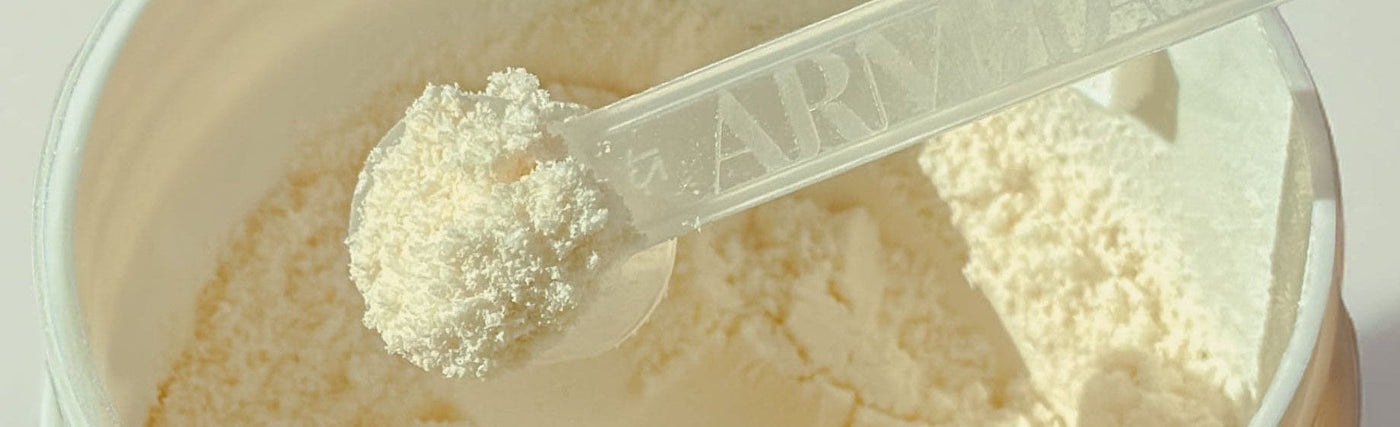 A scoop inside an ARMRA colostrum powder jar