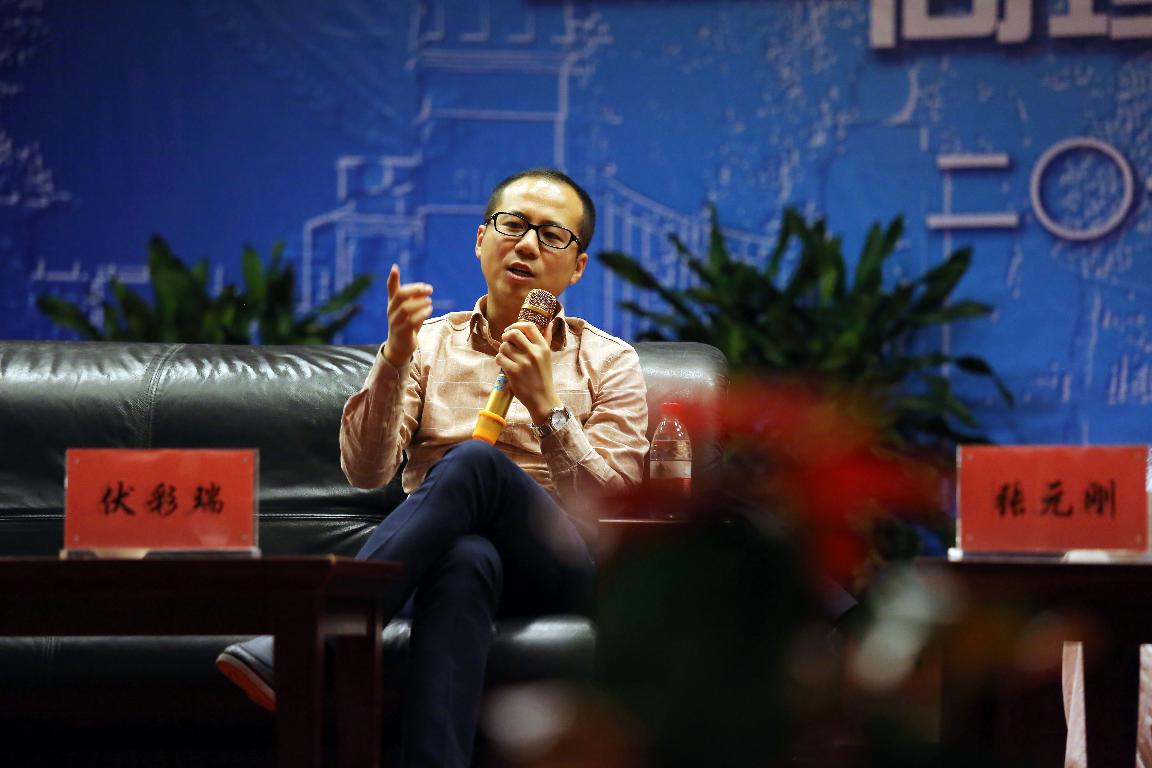 Cairui Fu speaking with a microphone at his university’s alumni entrepreneurship forum