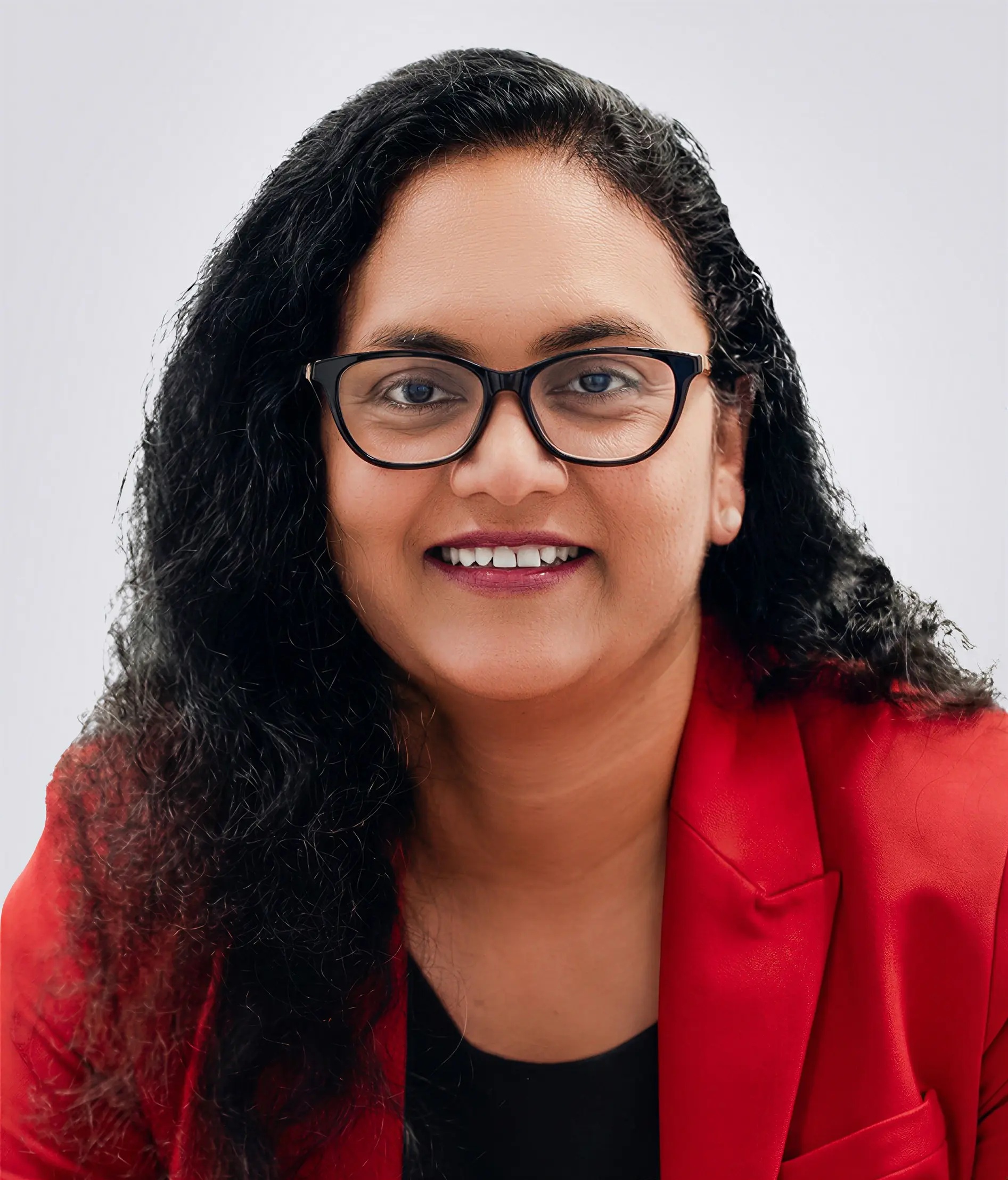 Arohak founder and CEO Surekha Reddy Pailla in glasses and a red jacket
