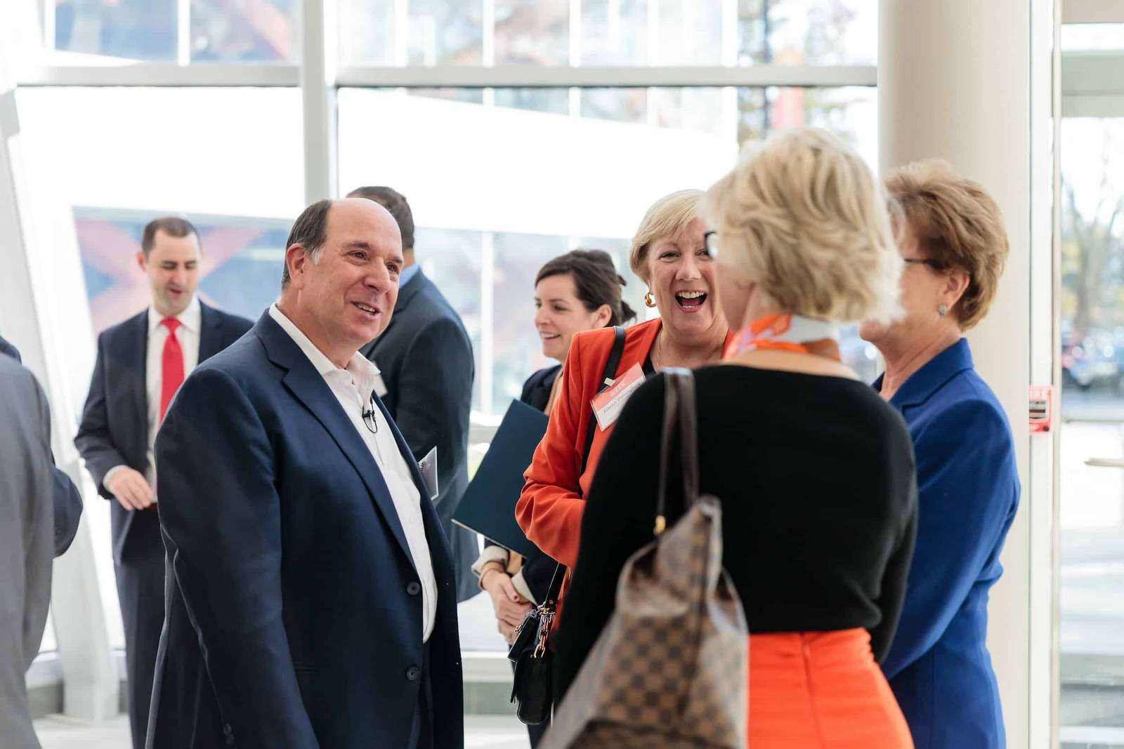 Aron Ain smiling in conversation with guests at a Kronos event