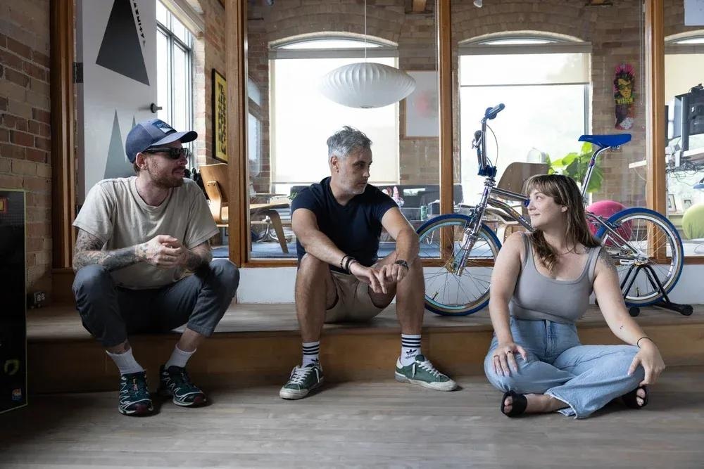 Art Mandalas, seated in the centre, talking with colleagues inside Community’s Toronto studio