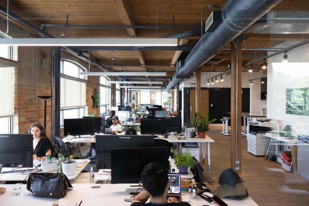 Desks, large windows, exposed brick and timber inside Community Agency’s studio