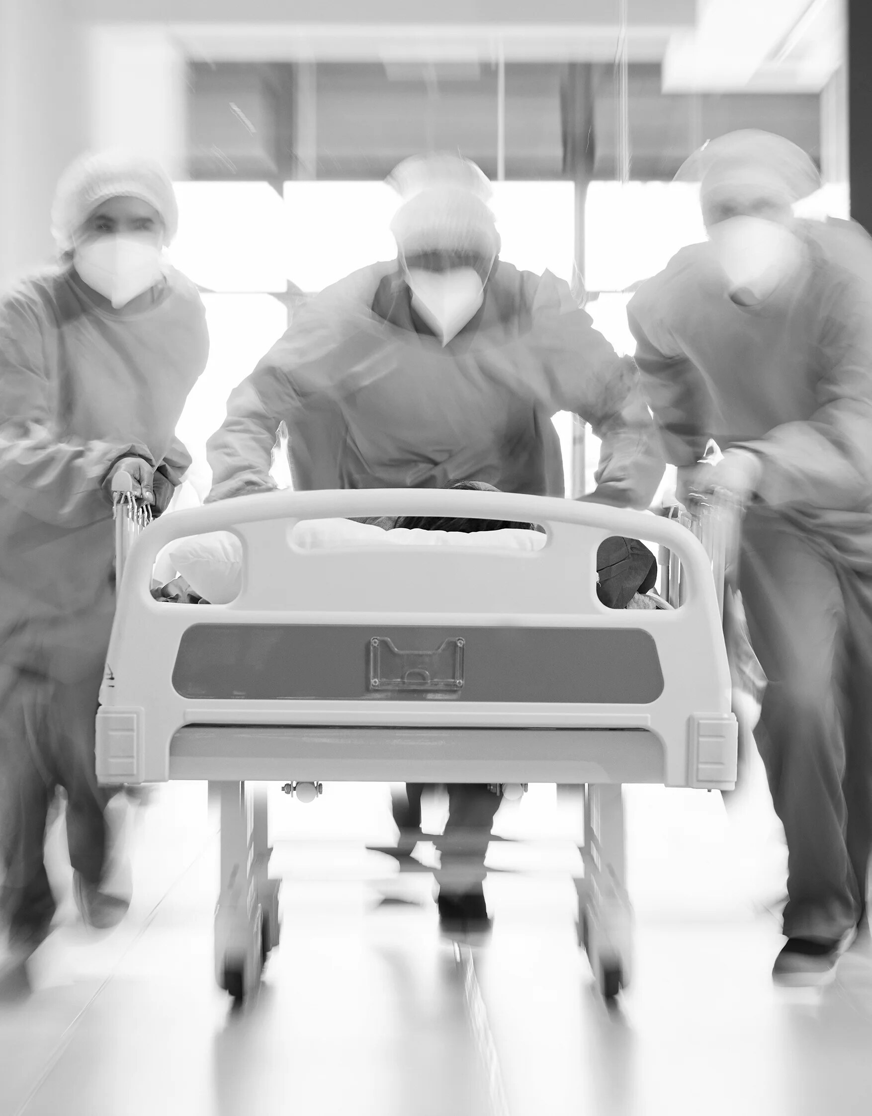 Medical workers moving a hospital bed, photographed through motion blur