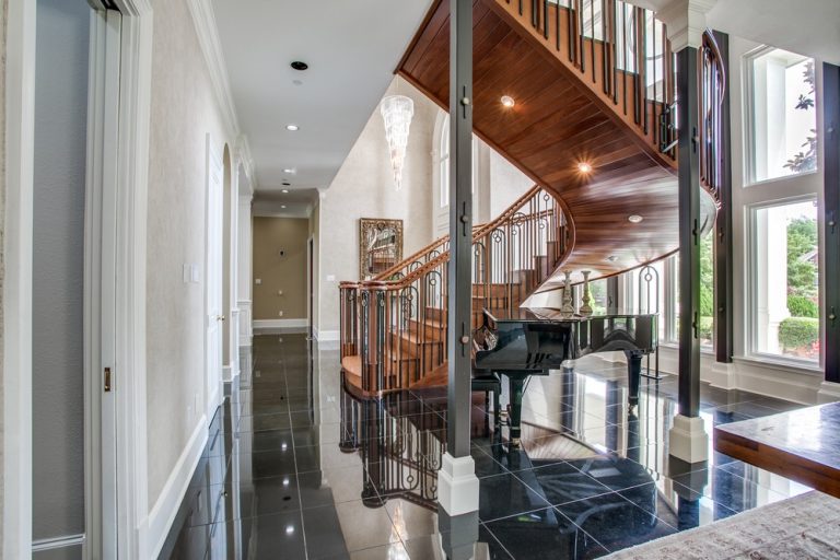 Curving wooden staircase and black tiled foyer inside Emmitt Smith’s former Dallas-area home