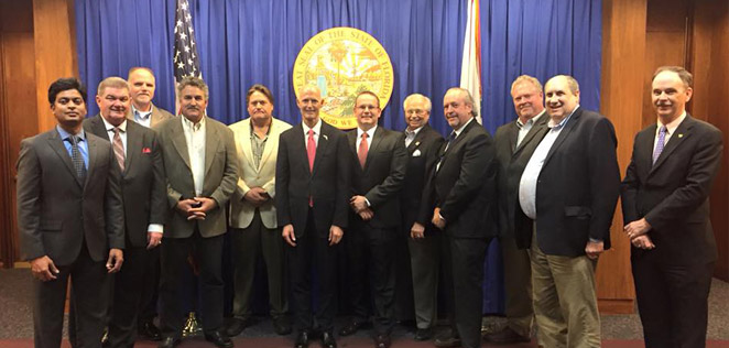 Arun Venkatesan with a group including Florida Governor Rick Scott at a 2016 meeting