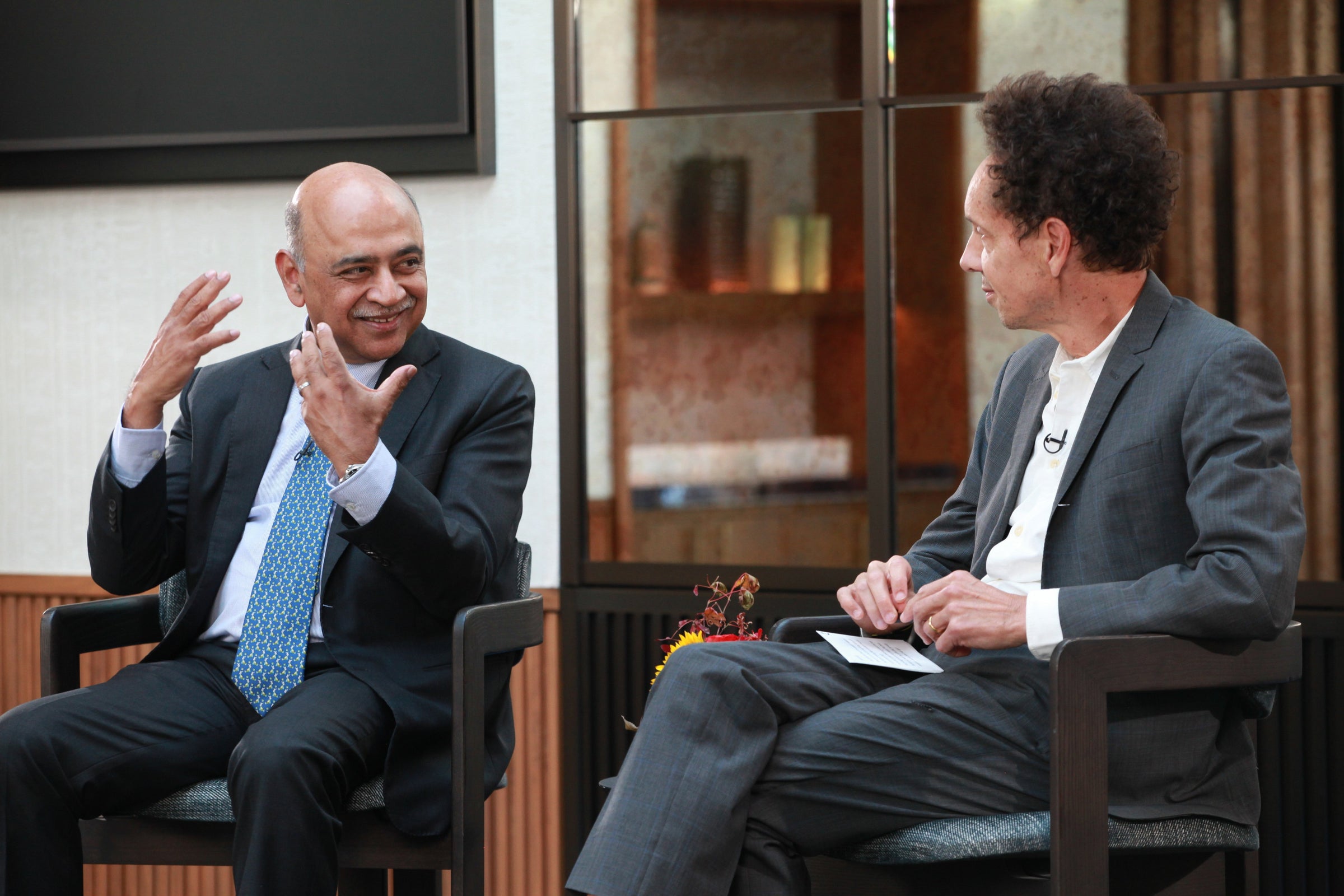 Arvind Krishna gestures while speaking with Malcolm Gladwell at a Smart Talks with IBM event