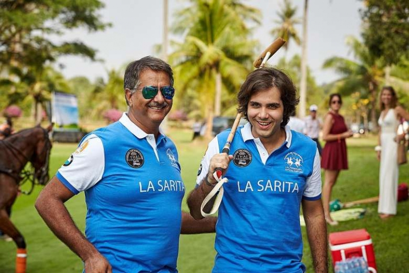 Asad Jumabhoy, at left, in a blue La Sarita polo shirt with a teammate on a polo field