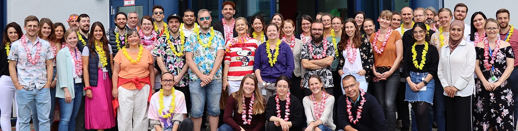 Ascend colleagues gathered outside, many wearing colorful shirts and flower garlands