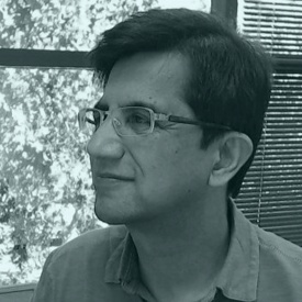 Archived black-and-white portrait of Ashhad Syed, wearing glasses and looking to the side