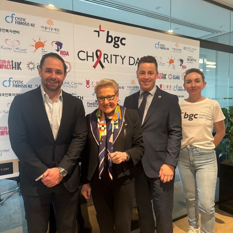 Four guests posing in front of a BGC Charity Day backdrop