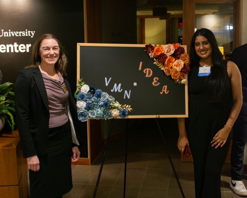Ashritha Kallem, at right, with another attendee beside an IDEA and VMN event display