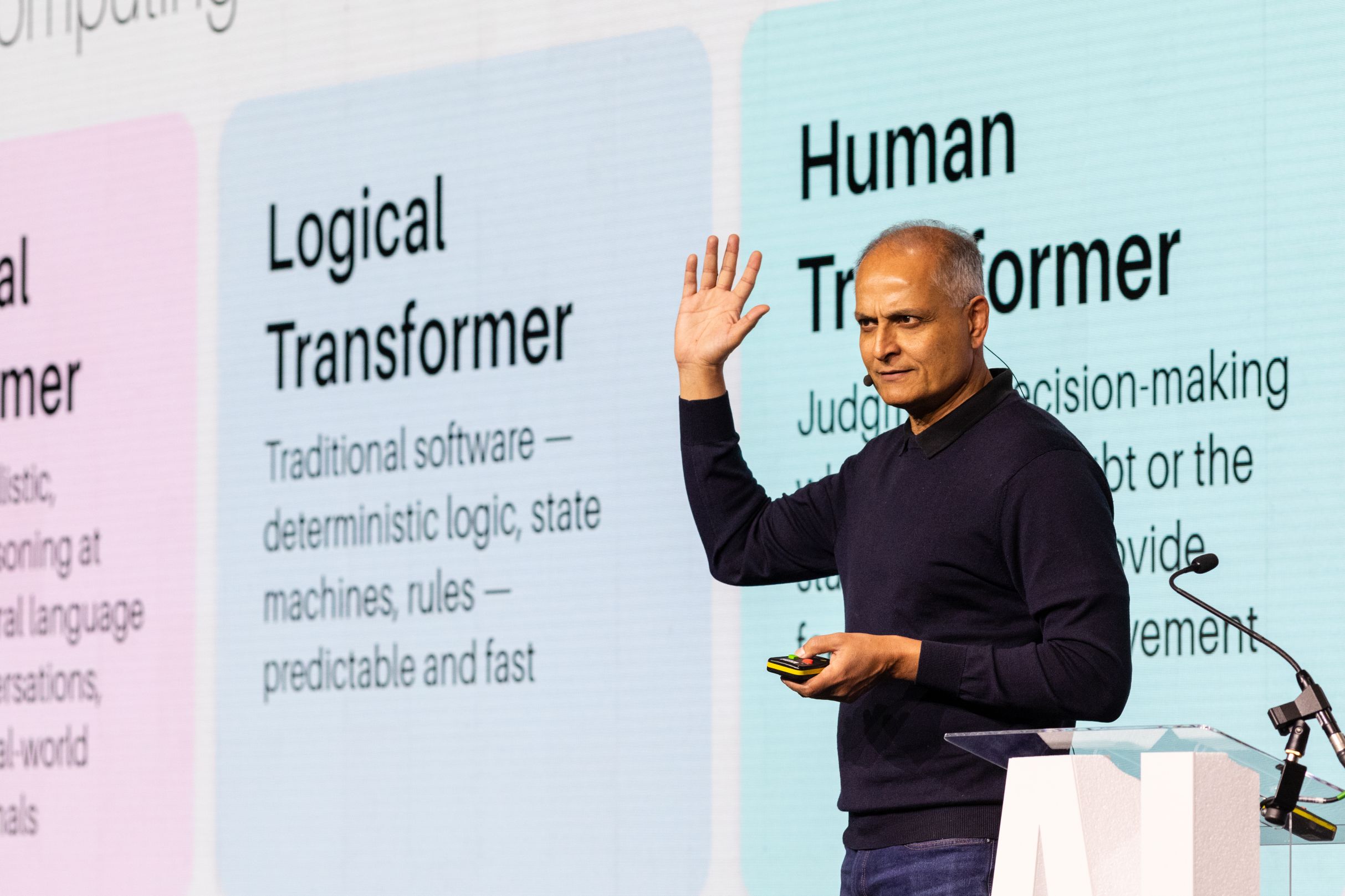Ashu Roy speaking onstage at eGain Solve26 London beside a slide about human decision-making