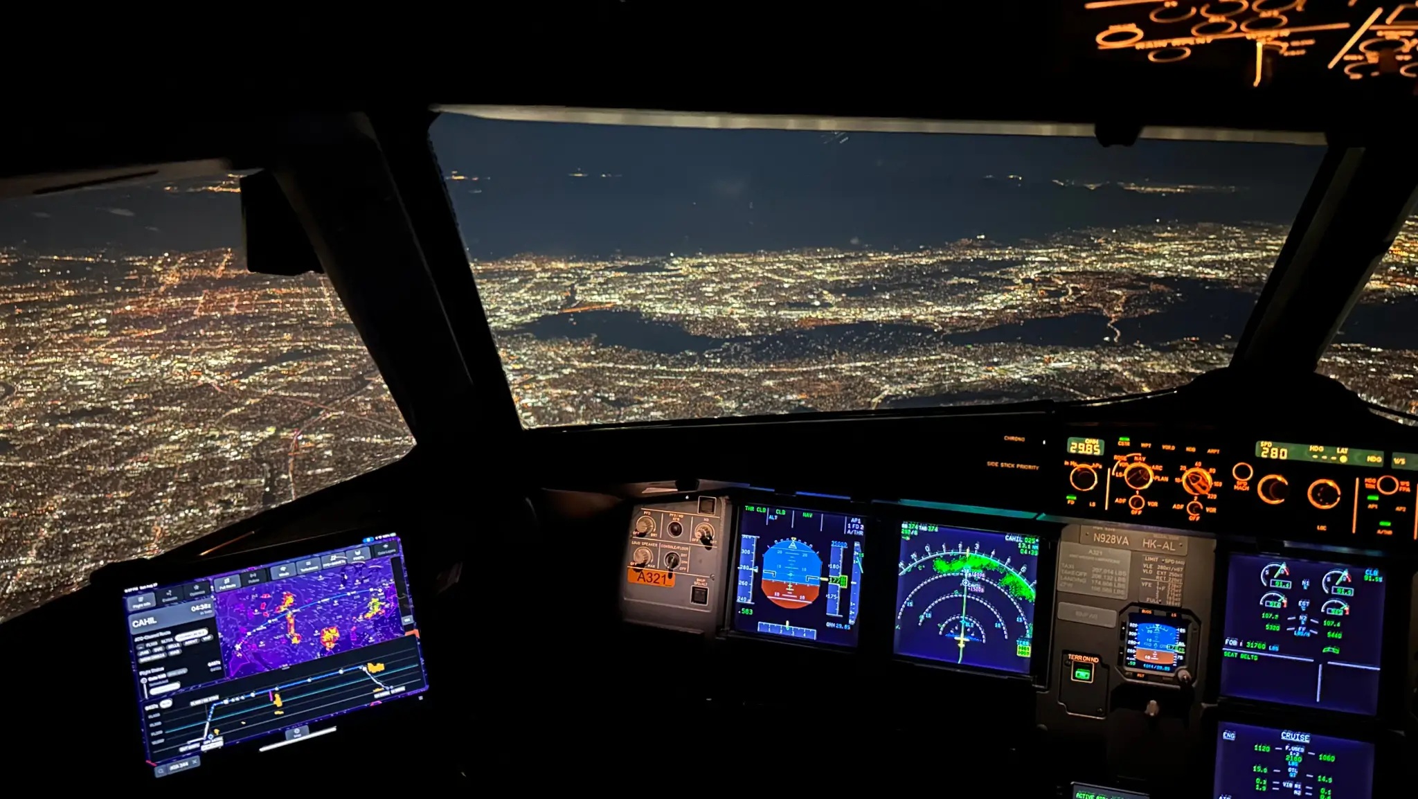 Nighttime cockpit with a tablet displaying aviation mapping software