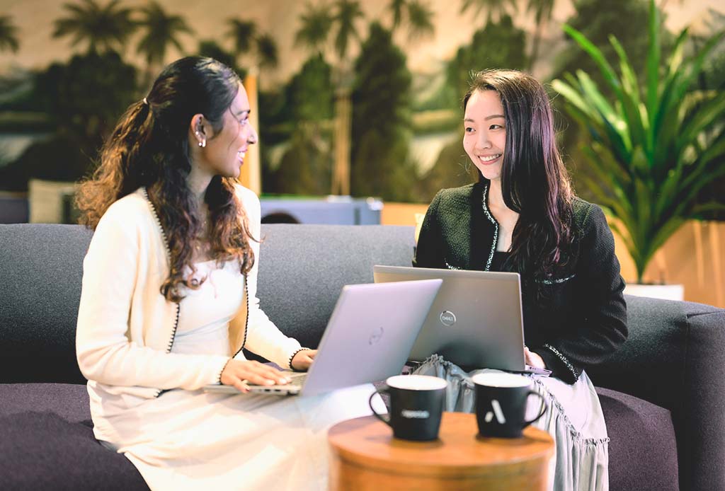Two Aspectus team members working together with laptops in an office
