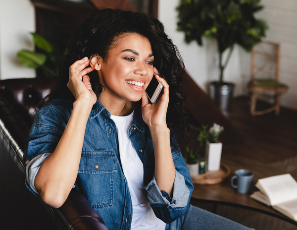 Company website photograph of a woman smiling during a phone call