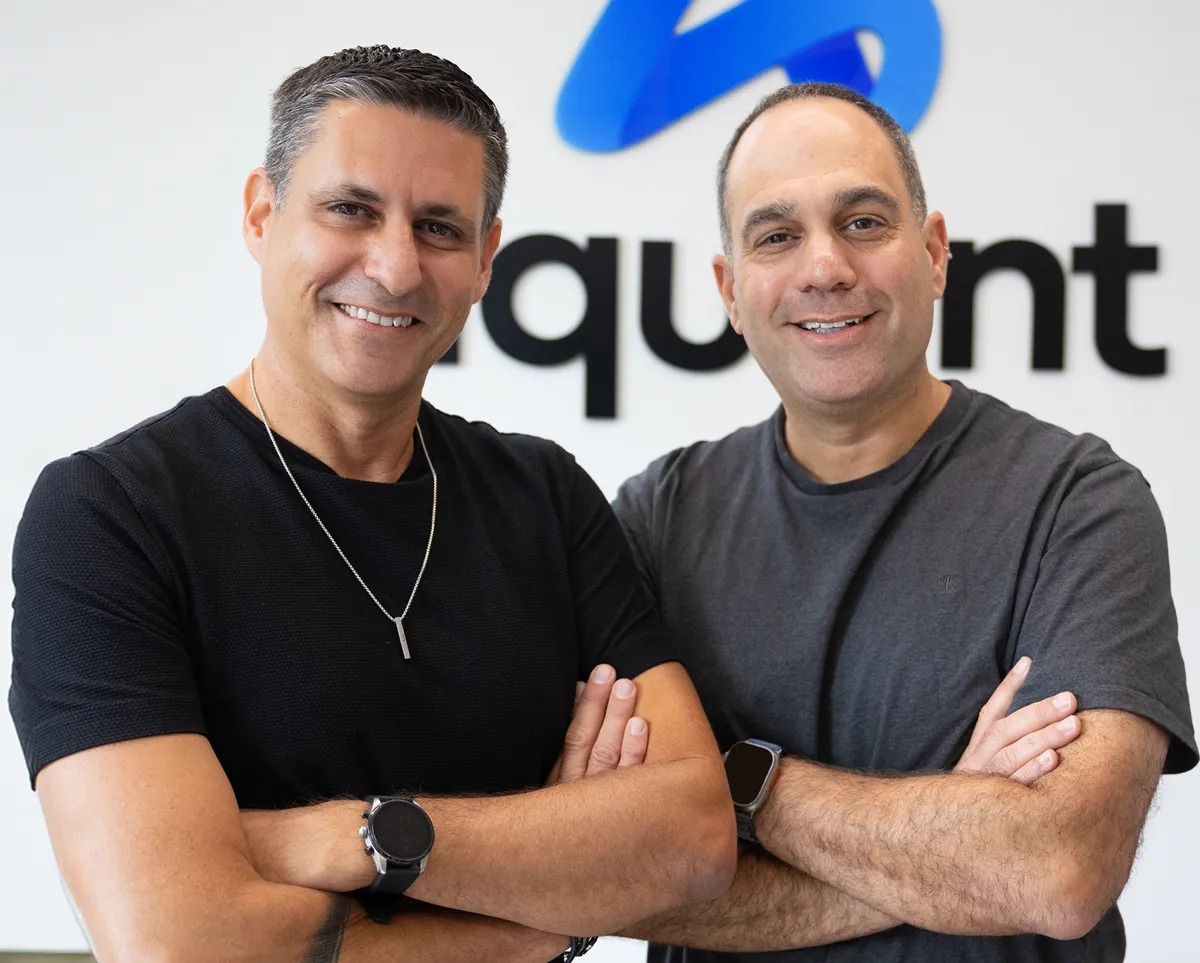 Aquant co-founders Shahar Chen and Assaf Melochna standing together in front of the company name
