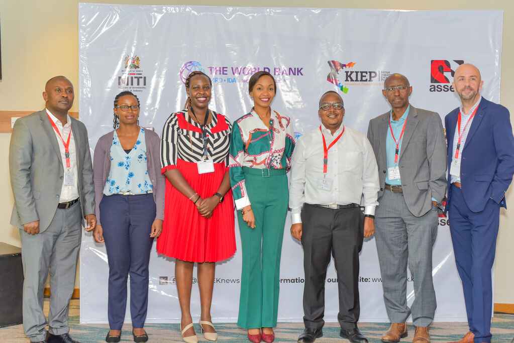 Seven participants pose in front of ASSEK, KIEP and World Bank event branding
