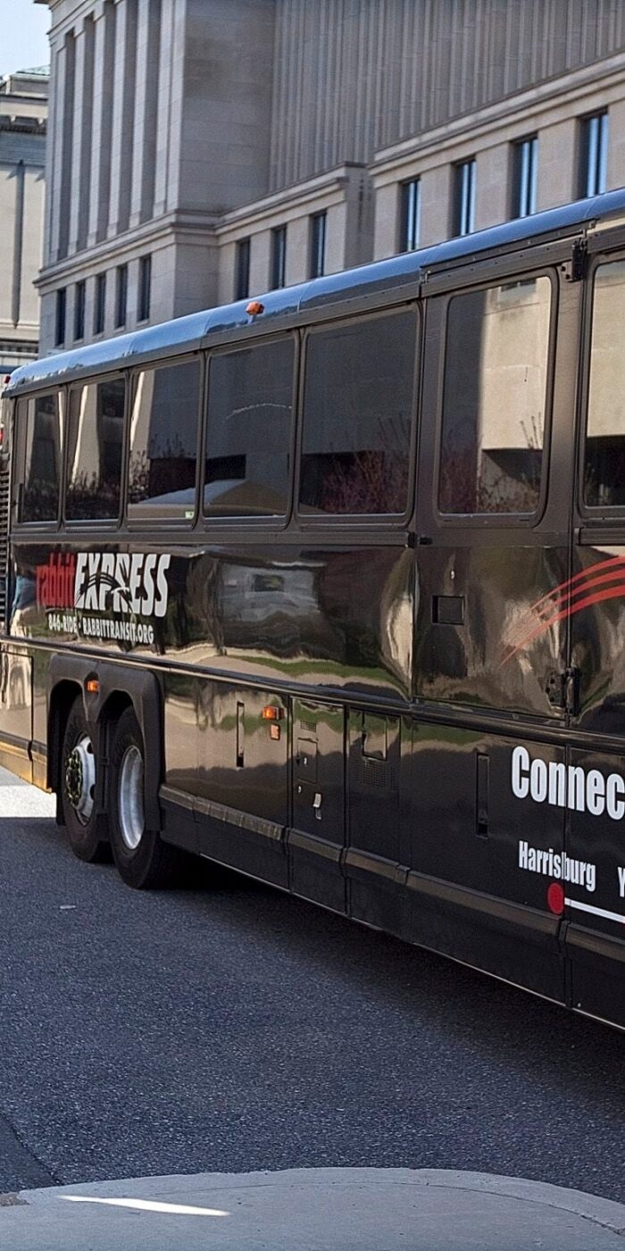 A rabbittransit express bus parked beside a city building