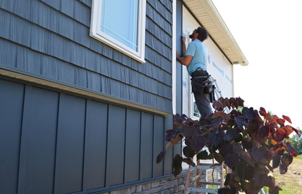 A contractor fitting ASCEND board-and-batten composite cladding