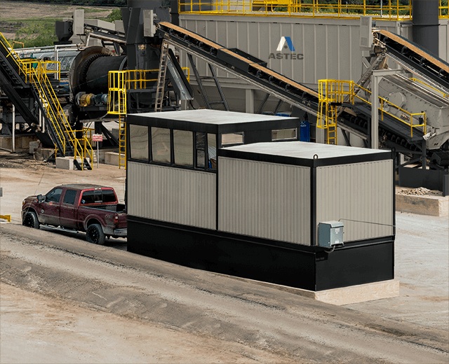 An ASTEC M-Pack control house with wraparound windows beside a pickup truck
