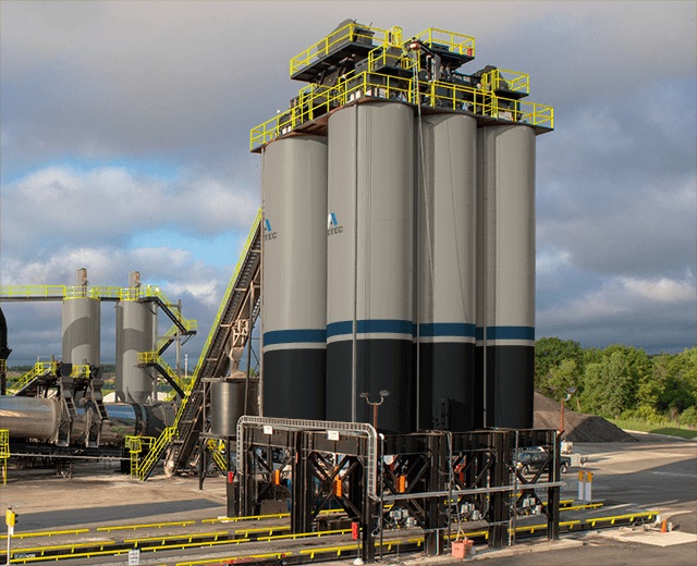 Four tall storage silos at an ASTEC M-Pack asphalt plant