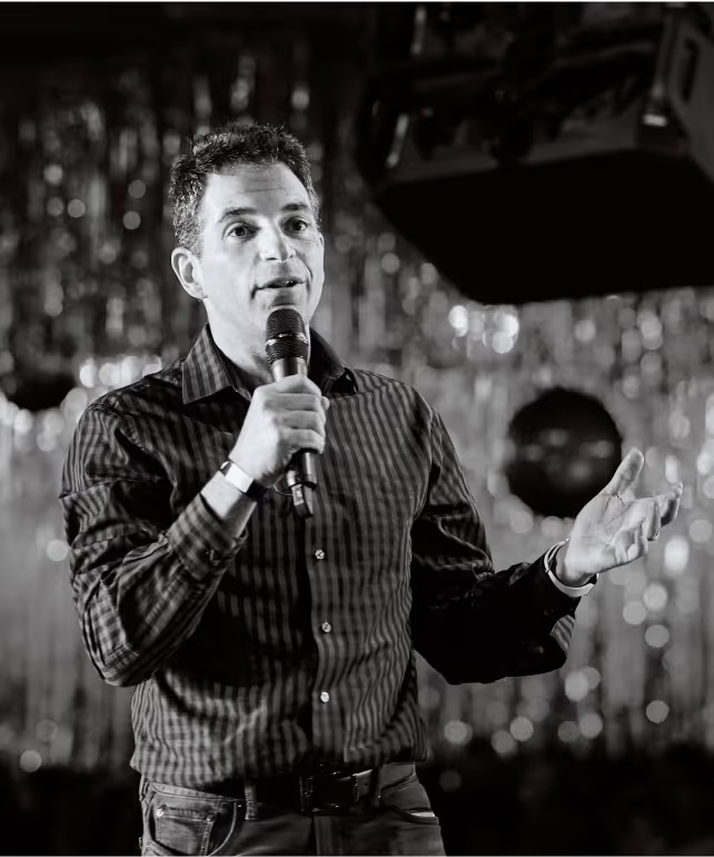 Astound Digital co-founder Ilya Vinogradsky speaking into a microphone on stage