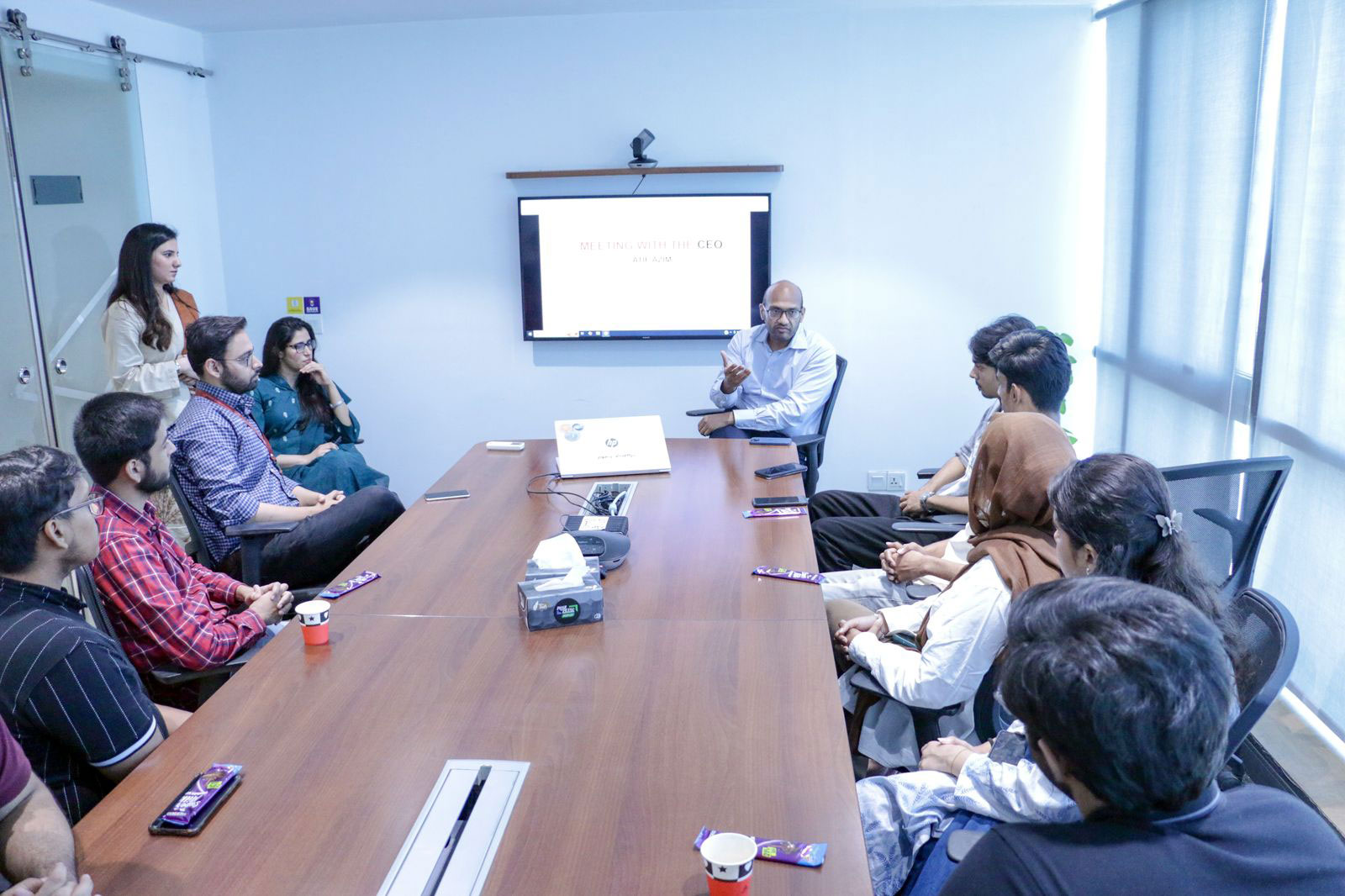 Atif Azim seated at the end of a conference table, speaking with visiting IBA Karachi students and VentureDive colleagues