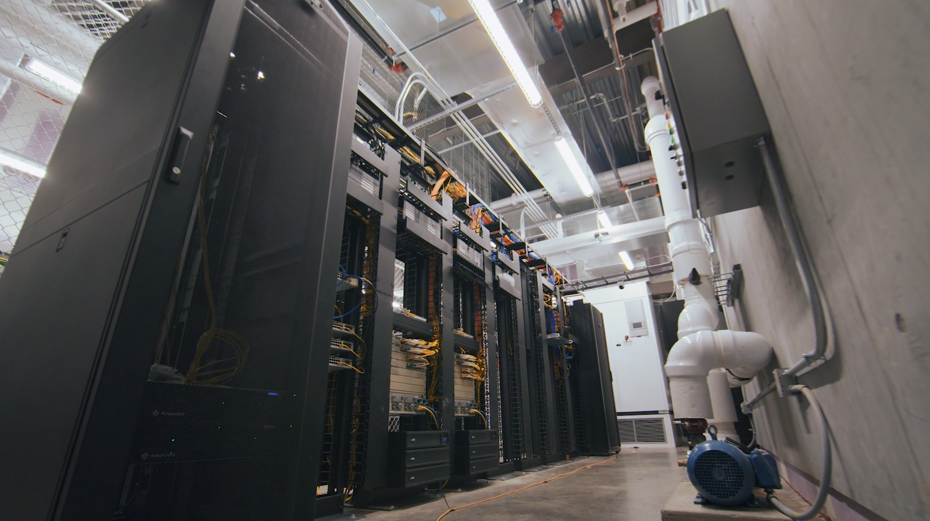 Tall equipment racks and network cabling inside an Allianz Field technology room