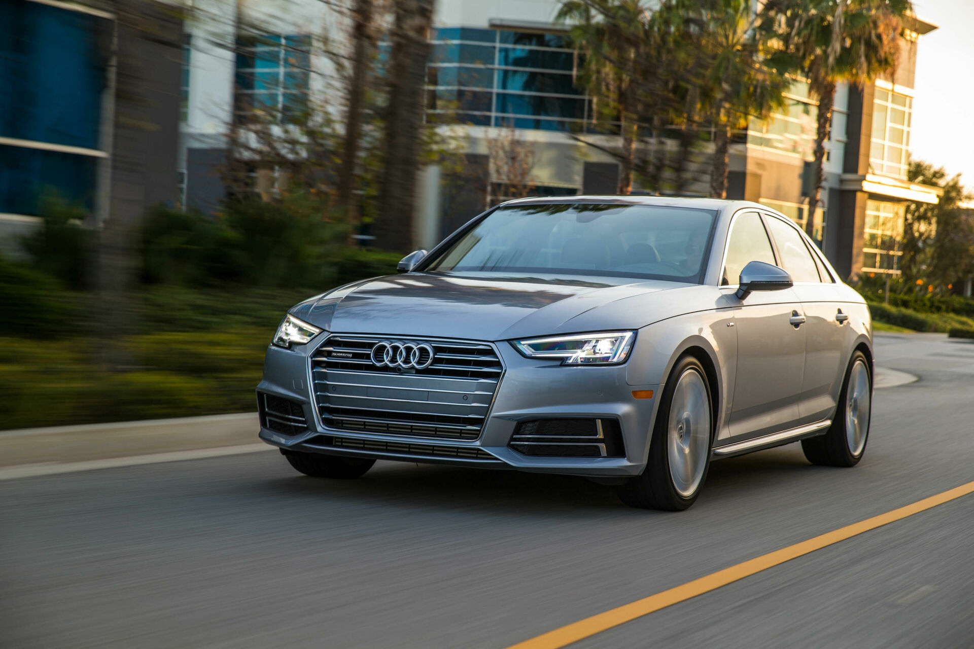 Silver Audi A4 driving past a building in an official Silvercar press photograph