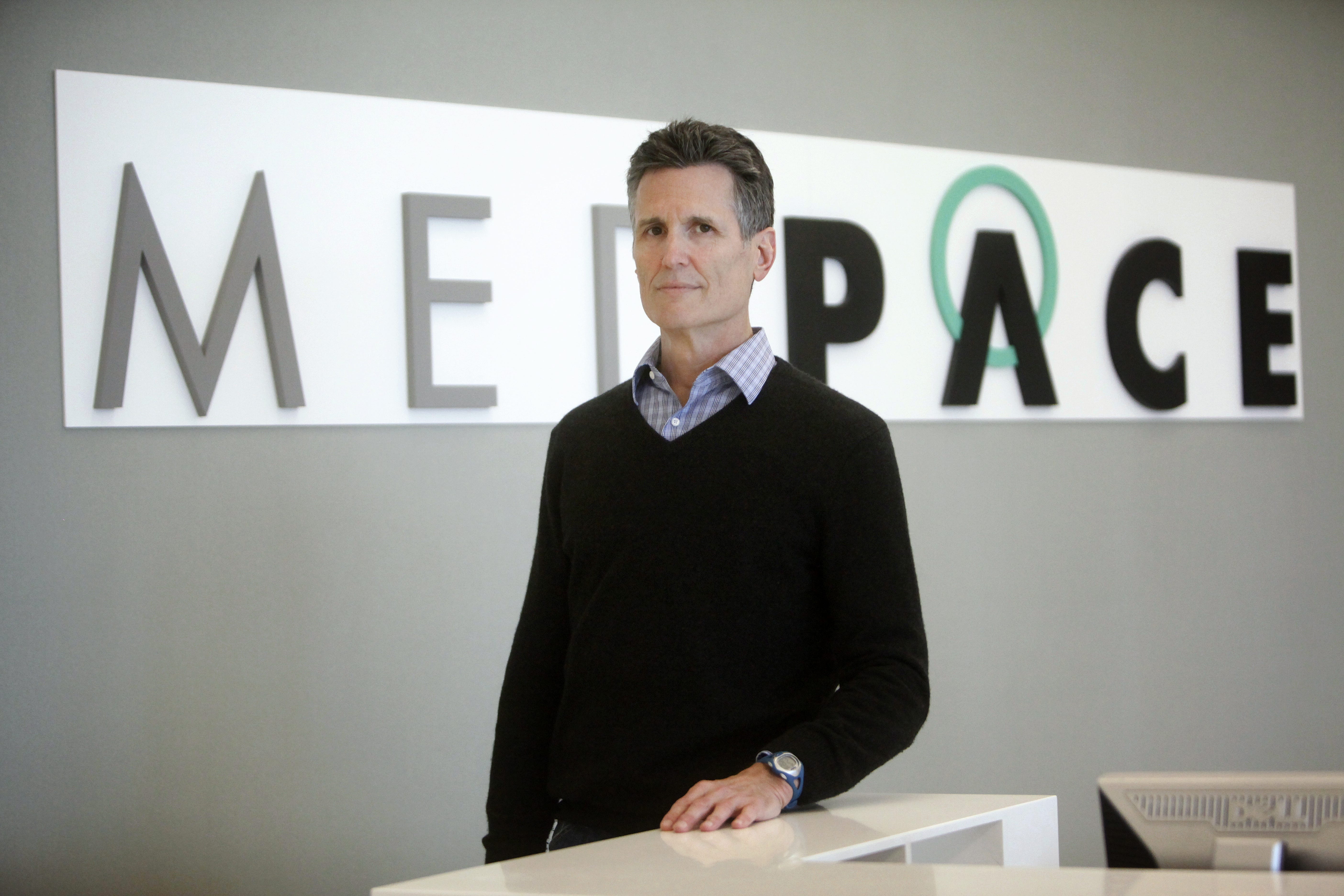 August Troendle standing at a reception desk beneath the Medpace lettering