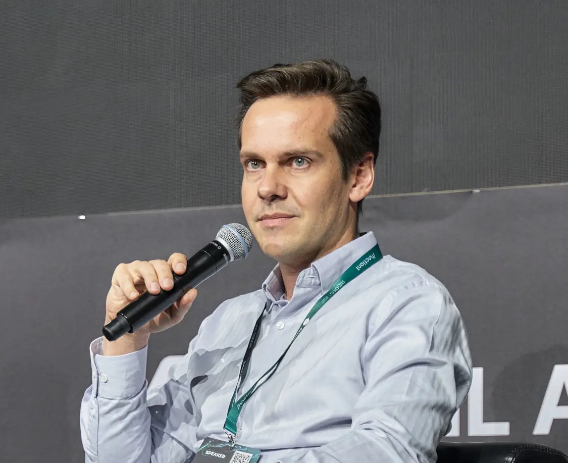 Aurelia Ventures co-founder Felix Kues holding a microphone