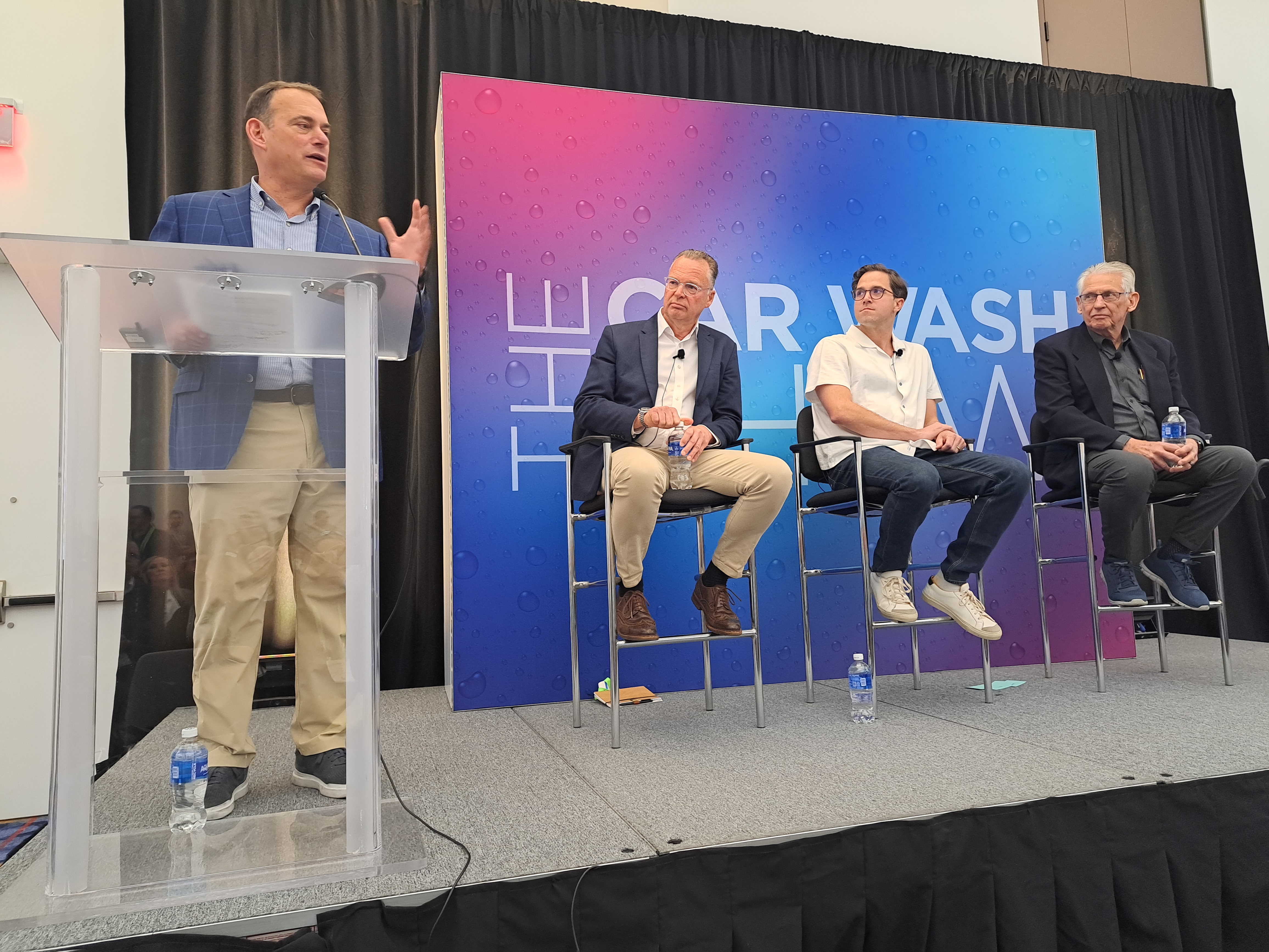 Austin Esecson seated at center during a car wash industry panel in Las Vegas