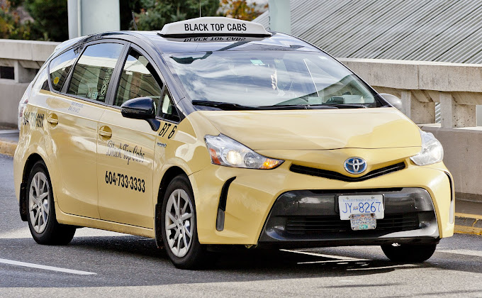 A yellow Black Top Cabs Toyota taxi parked in Vancouver