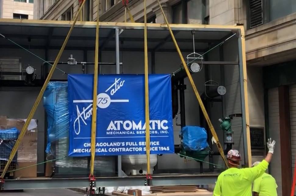 Atomatic Mechanical worker guides suspended mechanical equipment at a construction site