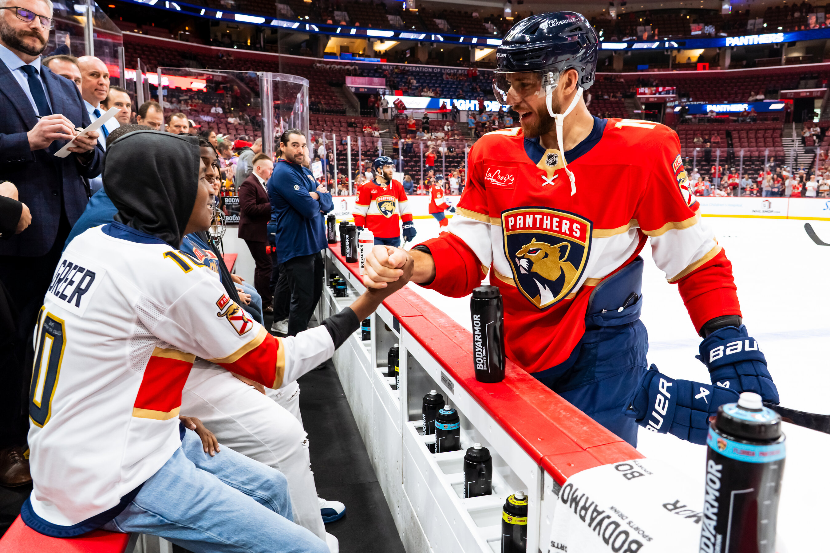 A young fan meets a Florida Panthers player beside the rink during an AutoNation-supported patient experience